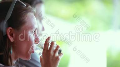 美丽的女商人在户外咖啡馆放松，在模糊的背景下喝水。 1920x1080